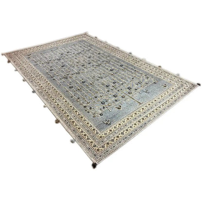 Double-sided rug with a blue-gray center, beige border ornaments, and tassels