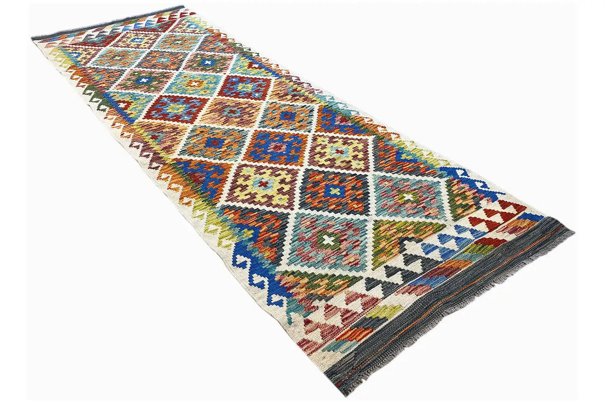 Angled view: multicolored Afghan runner with diamond design and dark border