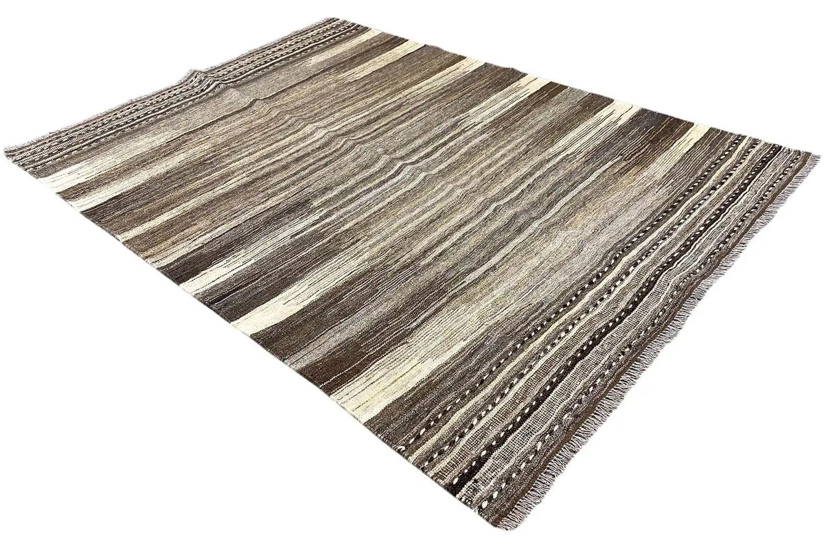 Kilim rug at an angle with brown-gray stripes and a distinctive edge