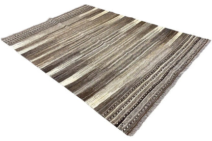 Kilim rug at an angle with brown-gray stripes and a distinctive edge