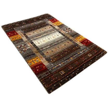 Rectangular Gabbeh rug with a dark background, yellow-red accents, and a light central field