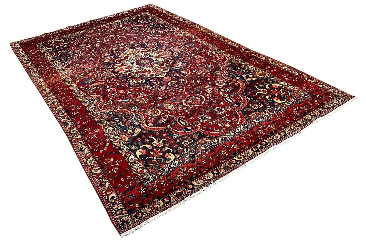 Red floral rug with paisley and braided ornaments, multicolored border