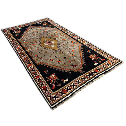Rug with a black base, beige medallion, and red/orange decorative stripes