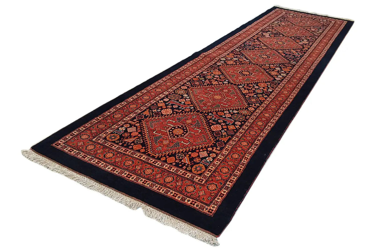 Oriental rug runner with red central medallions and dark edging, border, and fringes
