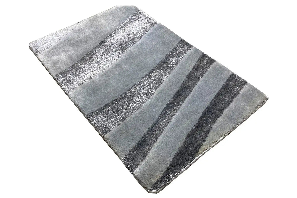 Rectangular designer rug, shown at an angle, with contrasting gray stripes