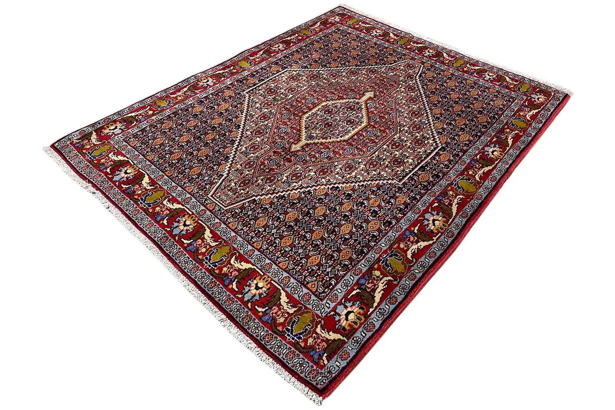 Dark red Hamadan rug with an ornamental pattern and border trim, laid flat.