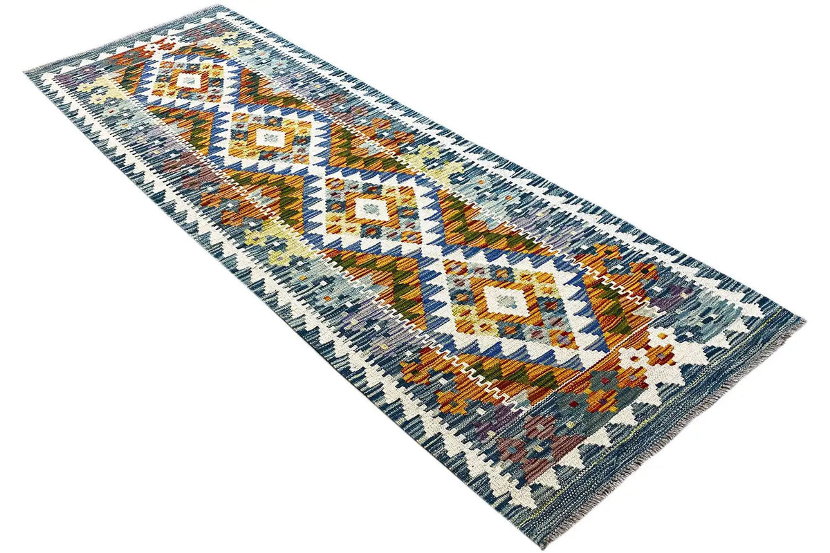 Afghan kilim runner, diagonal view, geometric diamonds, multicolored accents.