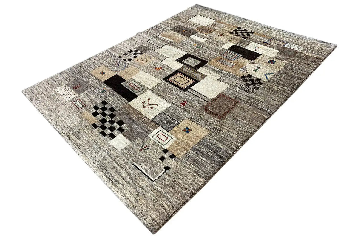 Carpet in an angled view with patchwork motifs in beige, gray, black, and small red details