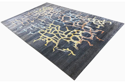 Hand-tufted rug neatly laid out, blue-gray with a yellow-outlined pattern