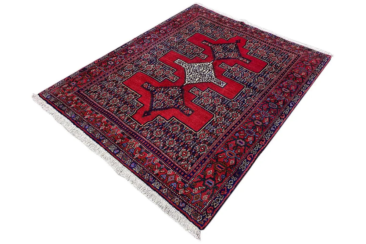 Hamadan rug in red and blue, lying diagonally, with fringes along the edge