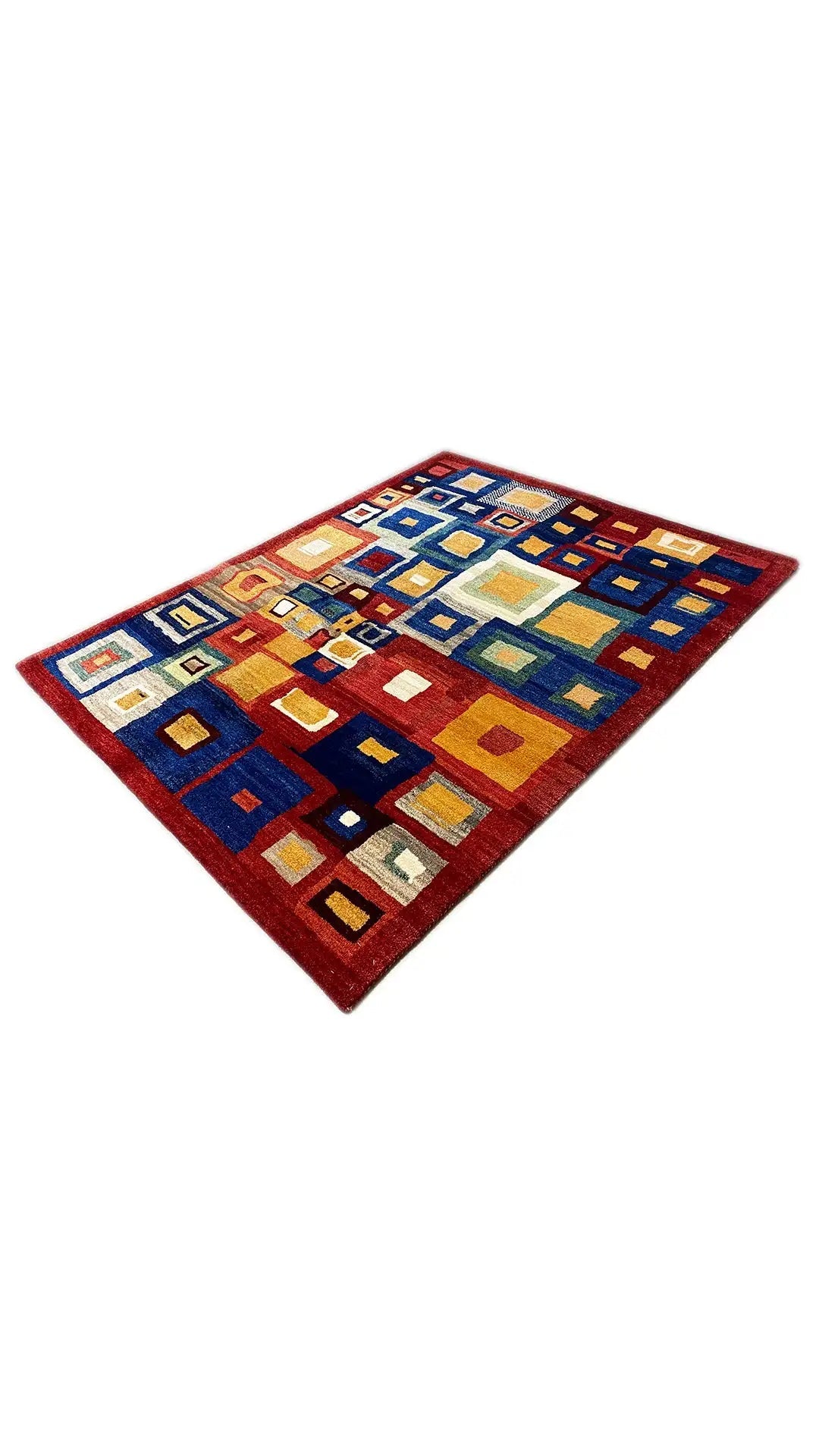 Gabbeh rug stretched out with geometric squares in shades of blue, red, and yellow