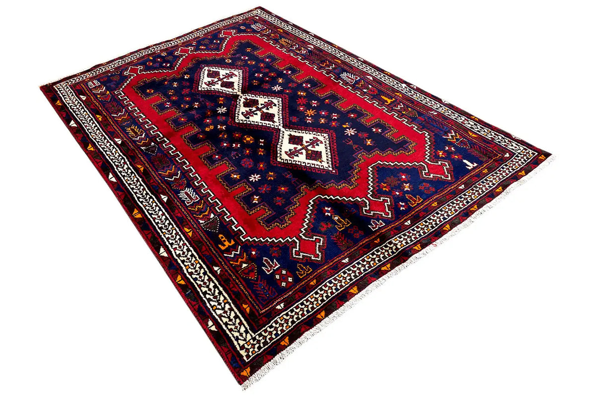 Oriental rug with a dark blue background, red central field, and multicolored border.