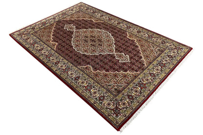 Indo Tabriz rug, diagonal view with a red field and golden ornamental border