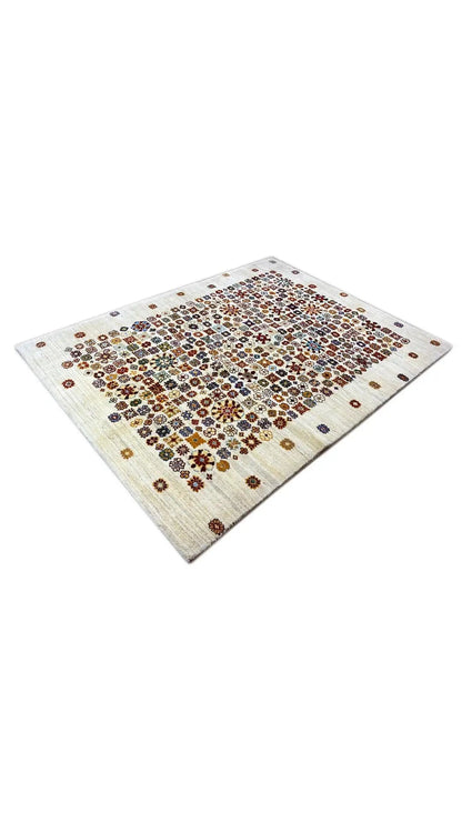 Corner view: rug with a colorful small-scale pattern on a light cream-colored background