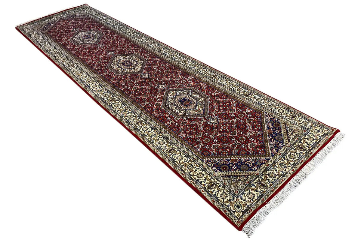 Bidjar runner laid diagonally: dark reddish brown, blue ornamental border, white fringes