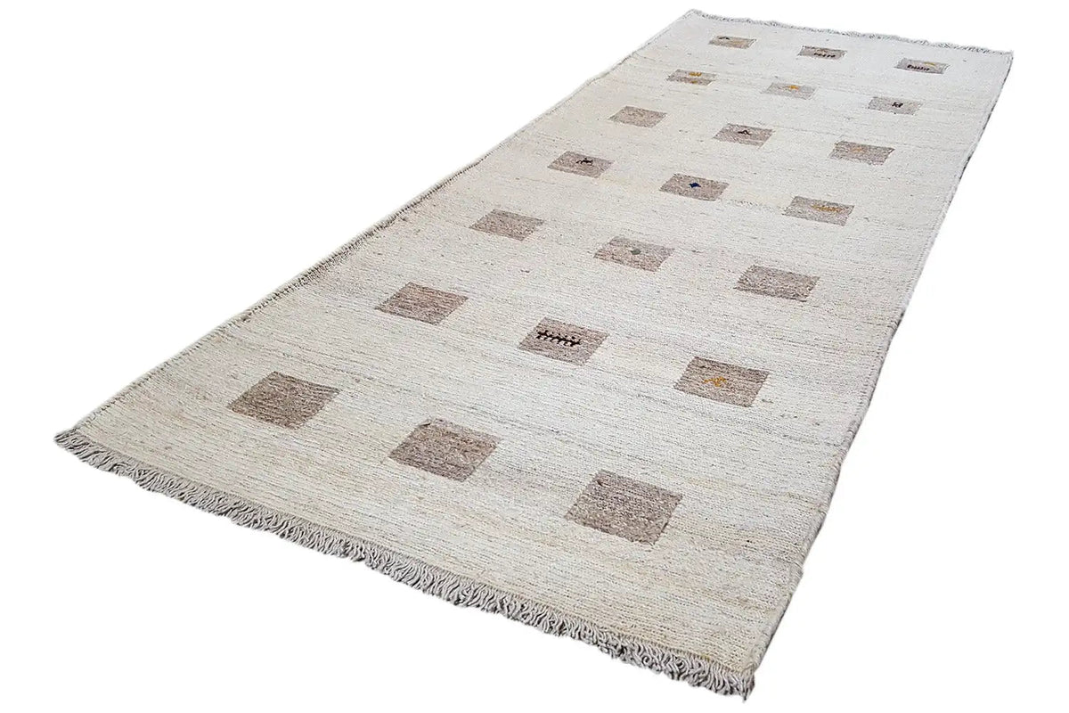 Kelim runner laid crosswise: beige background with brown square motifs, fringes along the edges