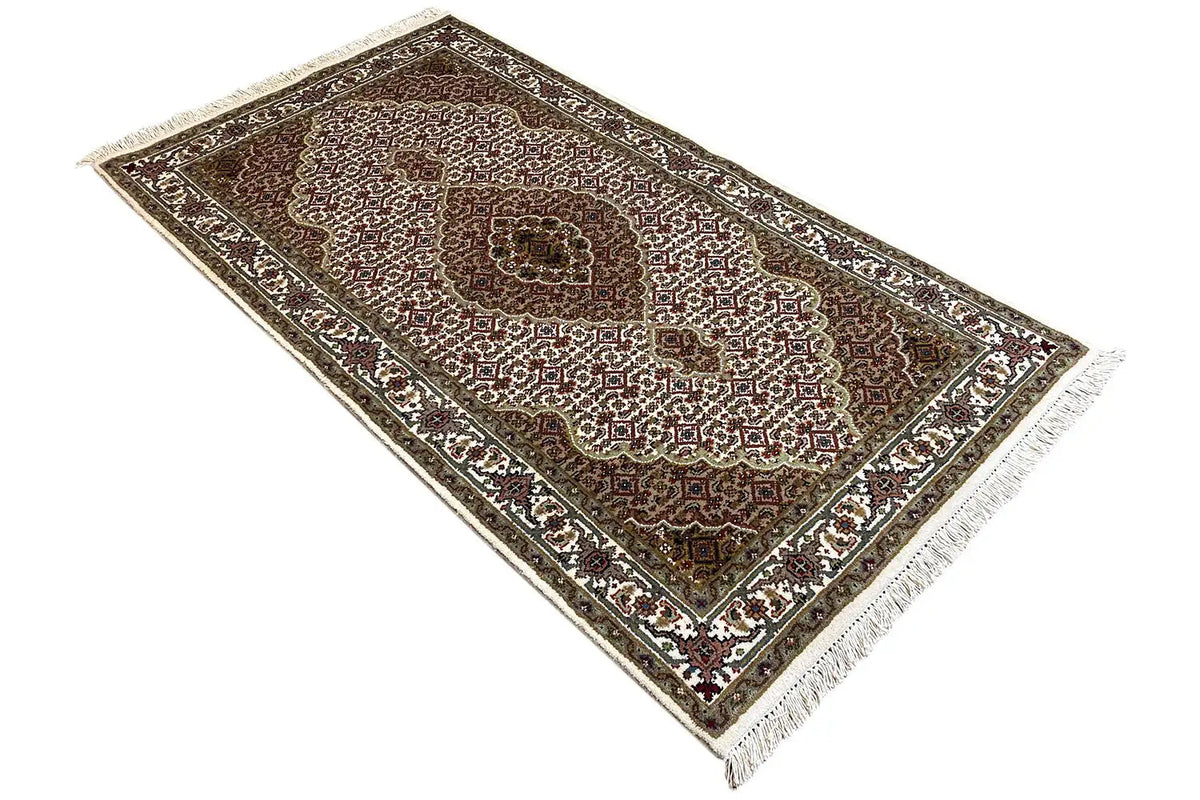 Indo Tabriz carpet: diagonal view, brown base motif with borders and fringes.