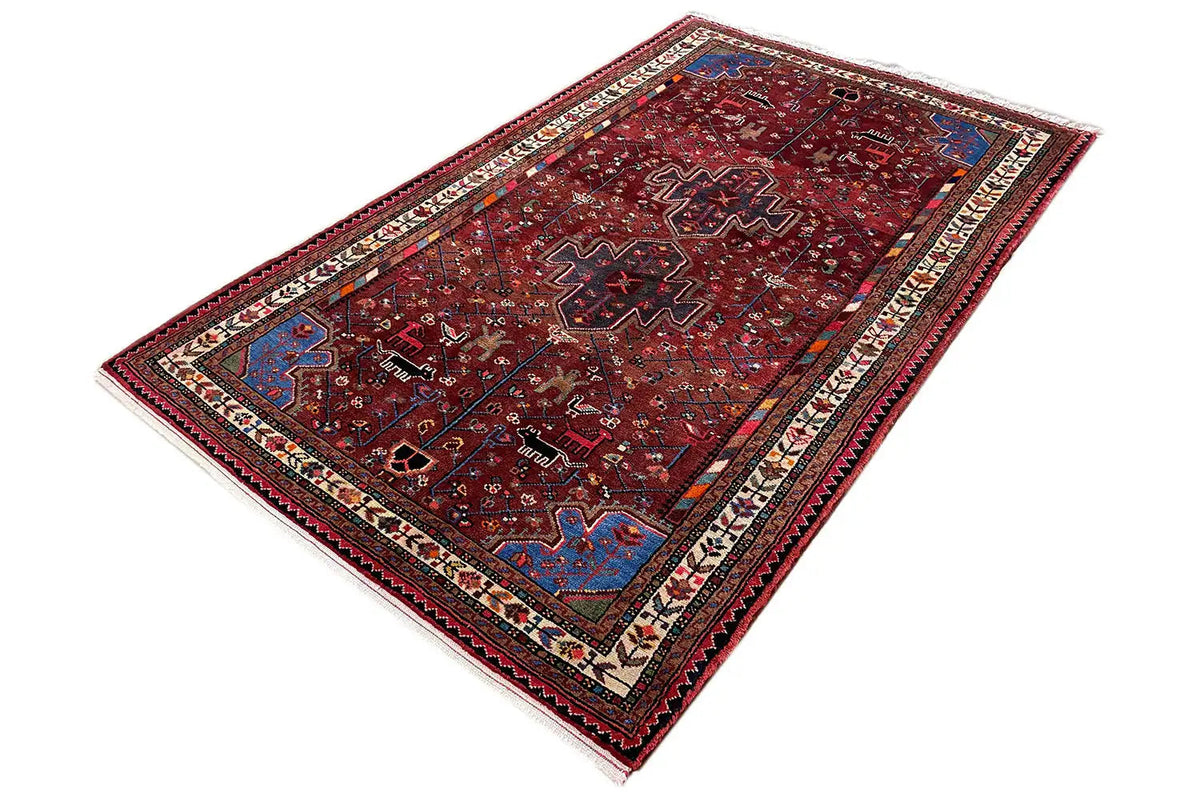 Hamadan carpet with red pattern and multicolored border, photographed from the side