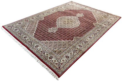 Rug with a maroon central medallion, beige ornamental elements, and a multi-row border.