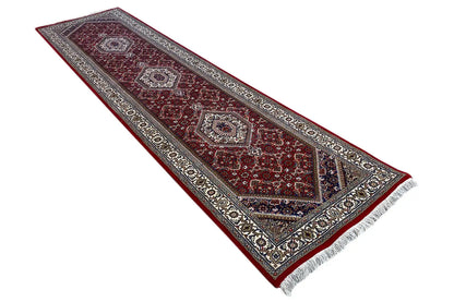 Bidjar runner diagonally: wine-red field with medallions, a wide border and fringes.