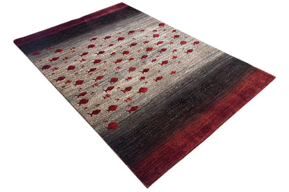 Gabbeh rug viewed from above at an angle, red pattern on a beige background with a dark red border