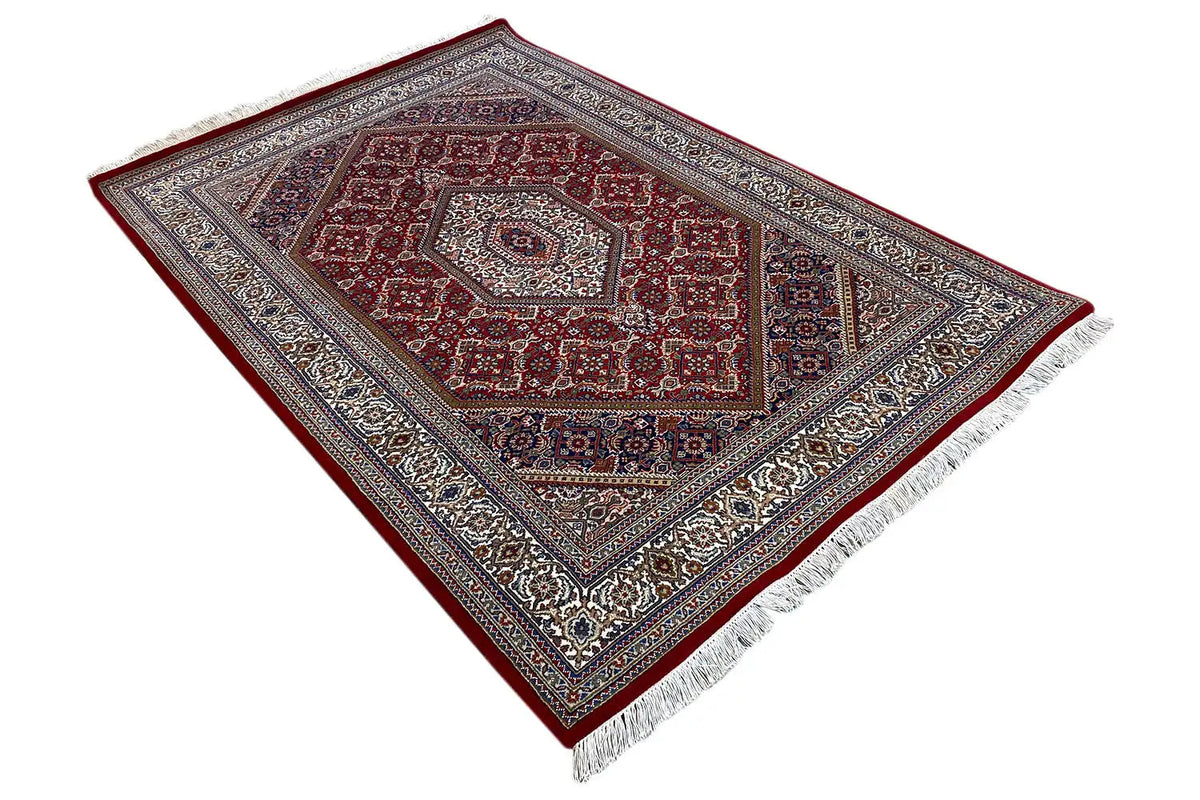 Rug 186x123 cm at an angle: red pattern, multicolored border, fringes