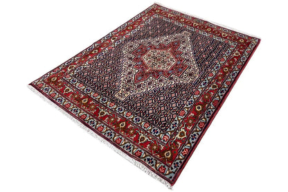 Hamadan rug viewed from above at an angle, with a central medallion and red-and-blue border
