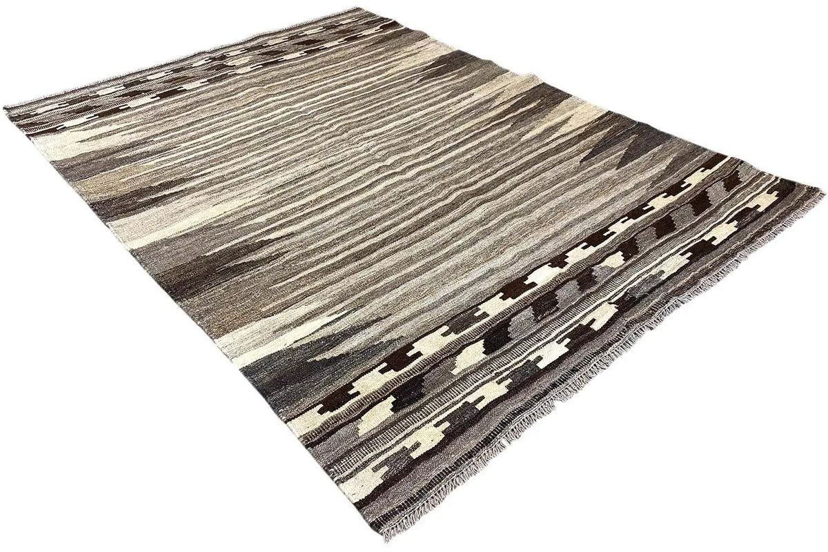 Kilim rug corner in an angled view with a geometric border