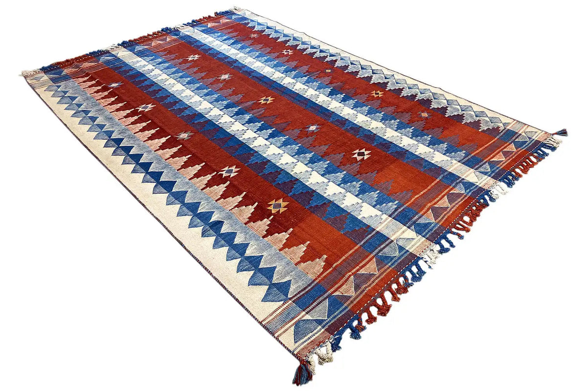 Striped rug in red, blue, and cream, with fringes at the corners