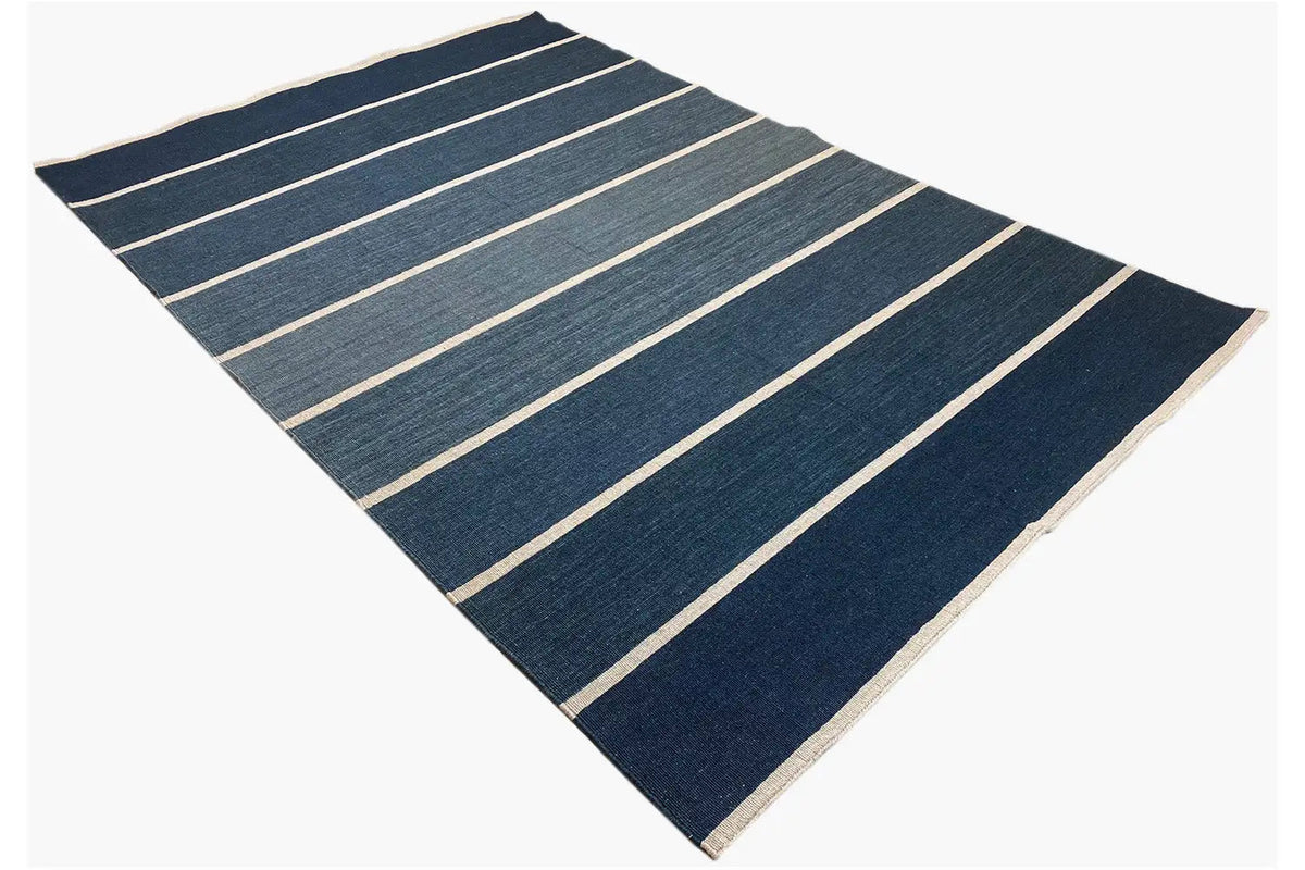 Flat-woven rug with diagonally aligned stripes in dark blue and beige
