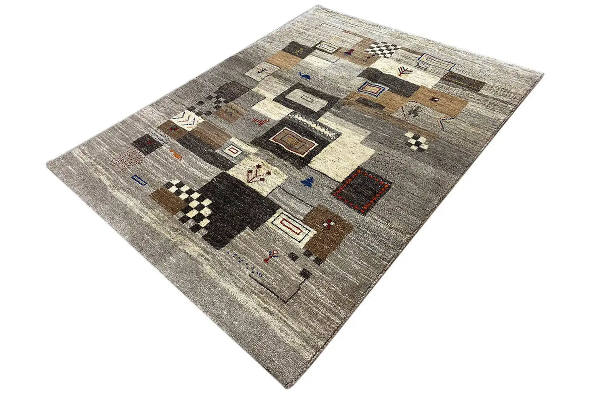 Gabbeh rug with a beige background, dark accents, and small, colorful patterned squares.