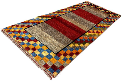 Gabbeh rug (190x83 cm), diagonal view: gray and red fields, colorful checkered border band.