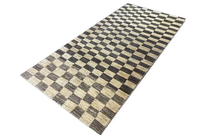 Rectangular Gabbeh rug, checkered pattern in black, beige and gray, laid at an angle