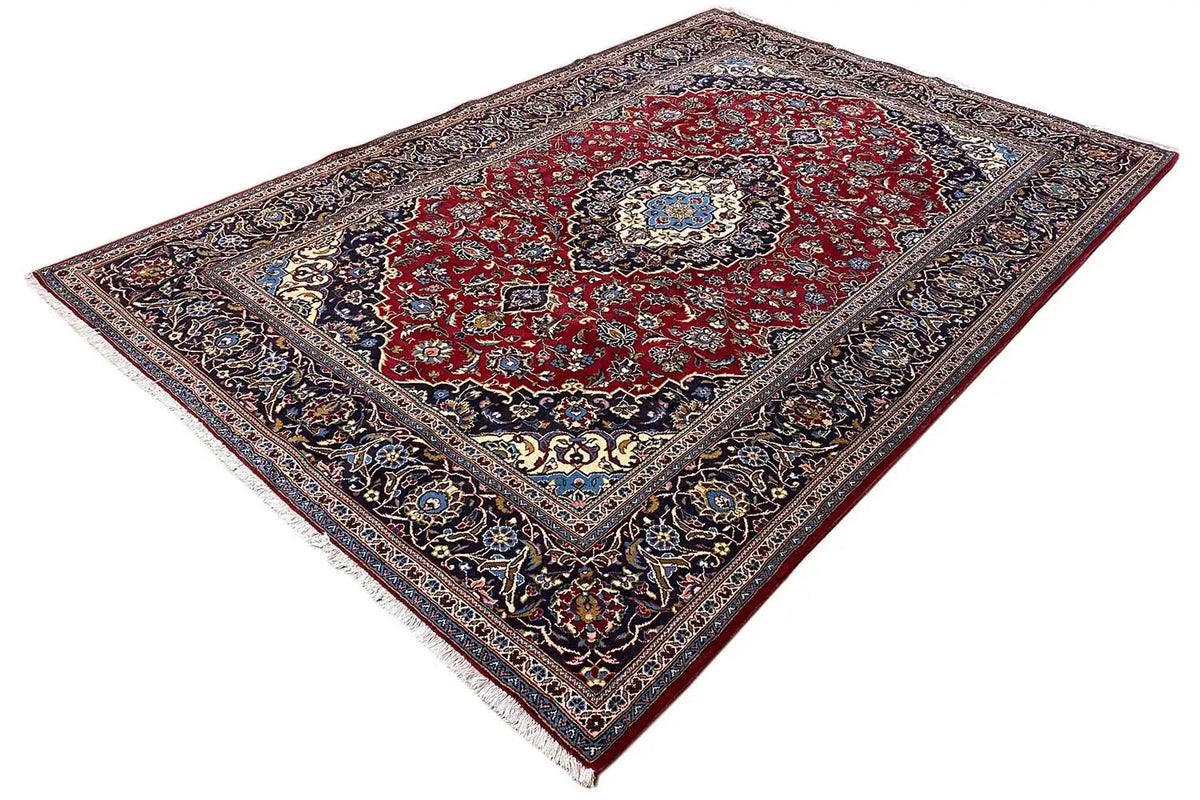 Keshan rug spread out in a diagonal view, red field with an ornamental border