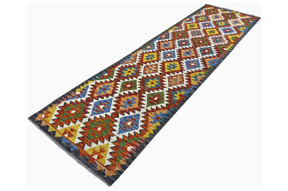 Kilim runner at an angle with a colorful tribal pattern and a dark border
