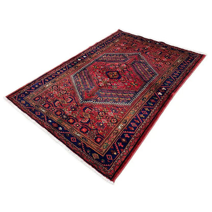 Red Hamadan rug with a dark blue border and geometric central motif