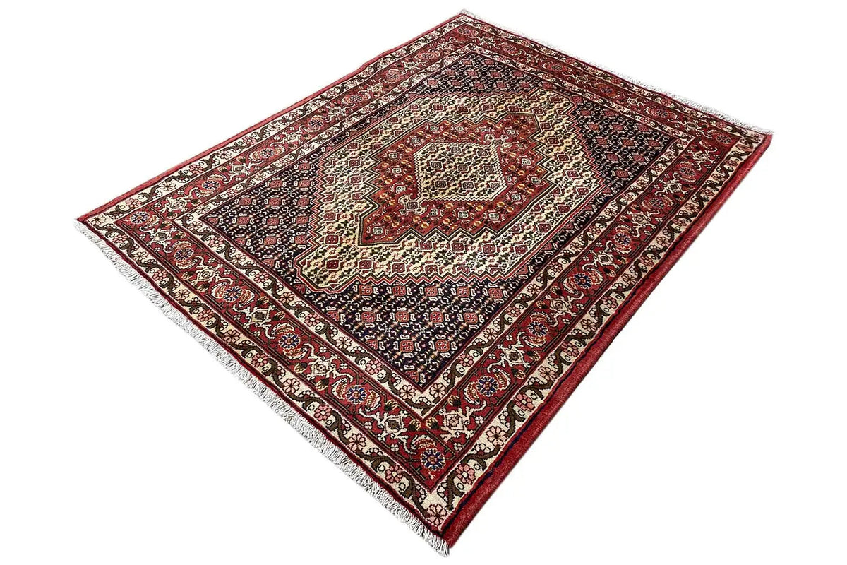 Carpet seen at an angle, dark blue and red pattern with wide ornamental borders