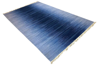 Blue kilim dhurrie rug with a worn look in the web image and gold-colored fringed border