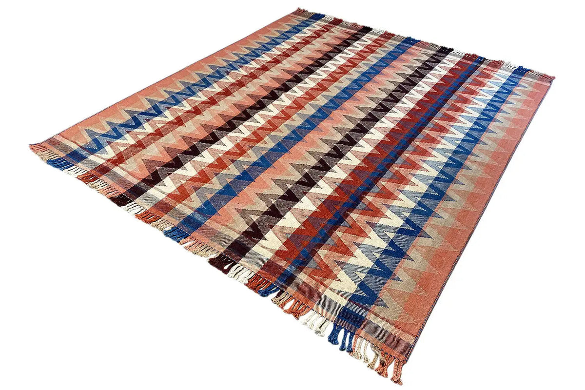 Rug with a diagonal zigzag pattern in rust, blue, black, and beige, with fringes