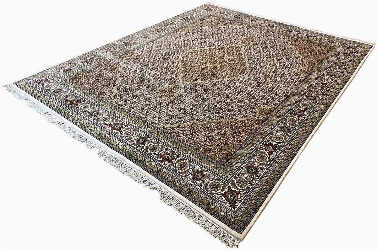 Rug with a central medallion, dark-accented border, fringed edges