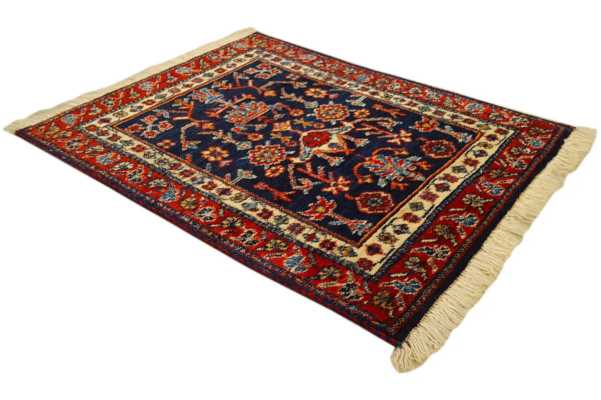 Square rug with a dark blue field, red border ornaments, and fringes