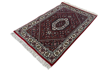 Carpet rotated diagonally, dark red ornamental pattern, cream edging, fringe