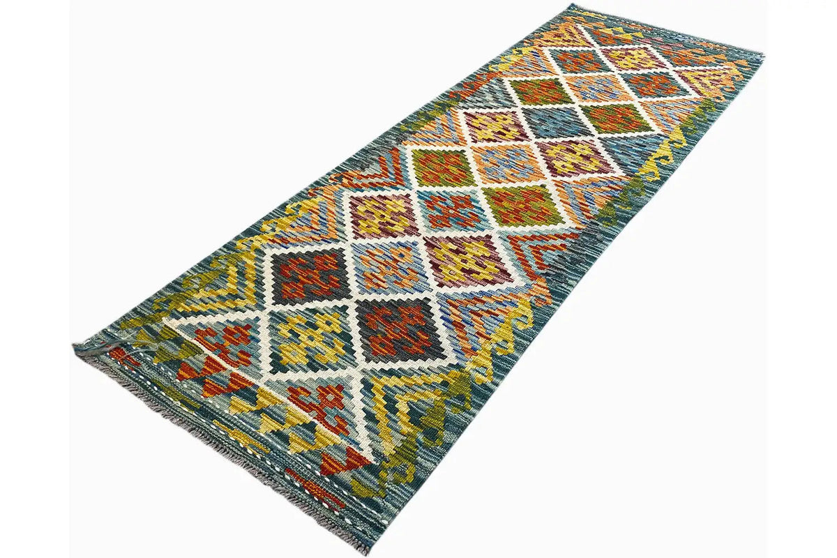 Afghan kilim runner in an angled view with a colorful diamond and zigzag pattern