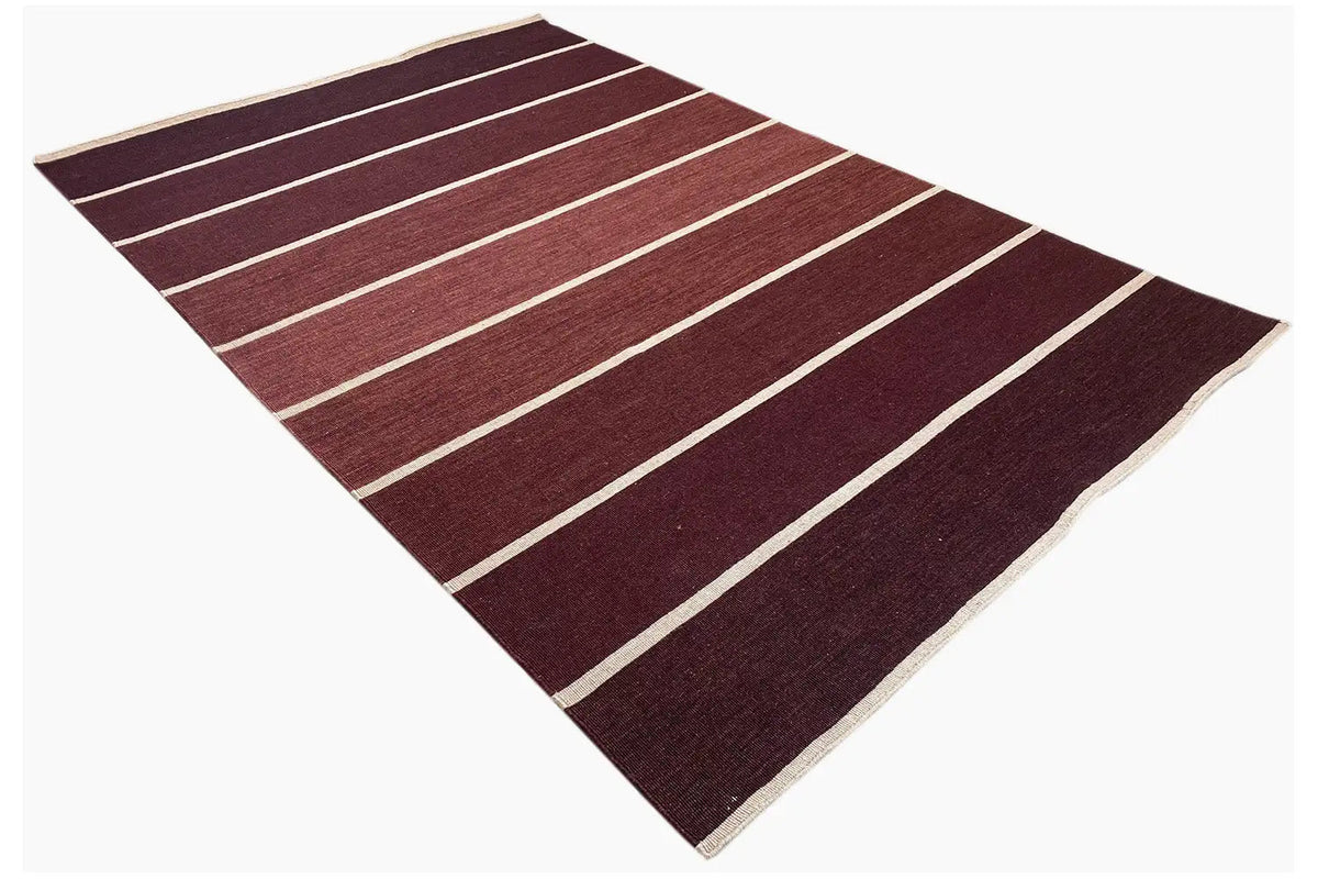 Rug with burgundy bands and white stripes, seemingly folded inside out