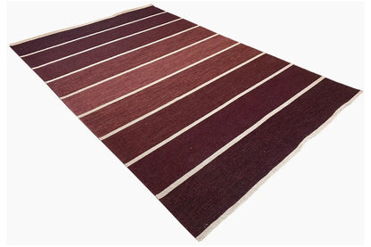 Rug with burgundy bands and white stripes, seemingly folded inside out