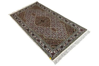 Tabriz carpet at an oblique angle, ornate border, fringes, dark brown pattern