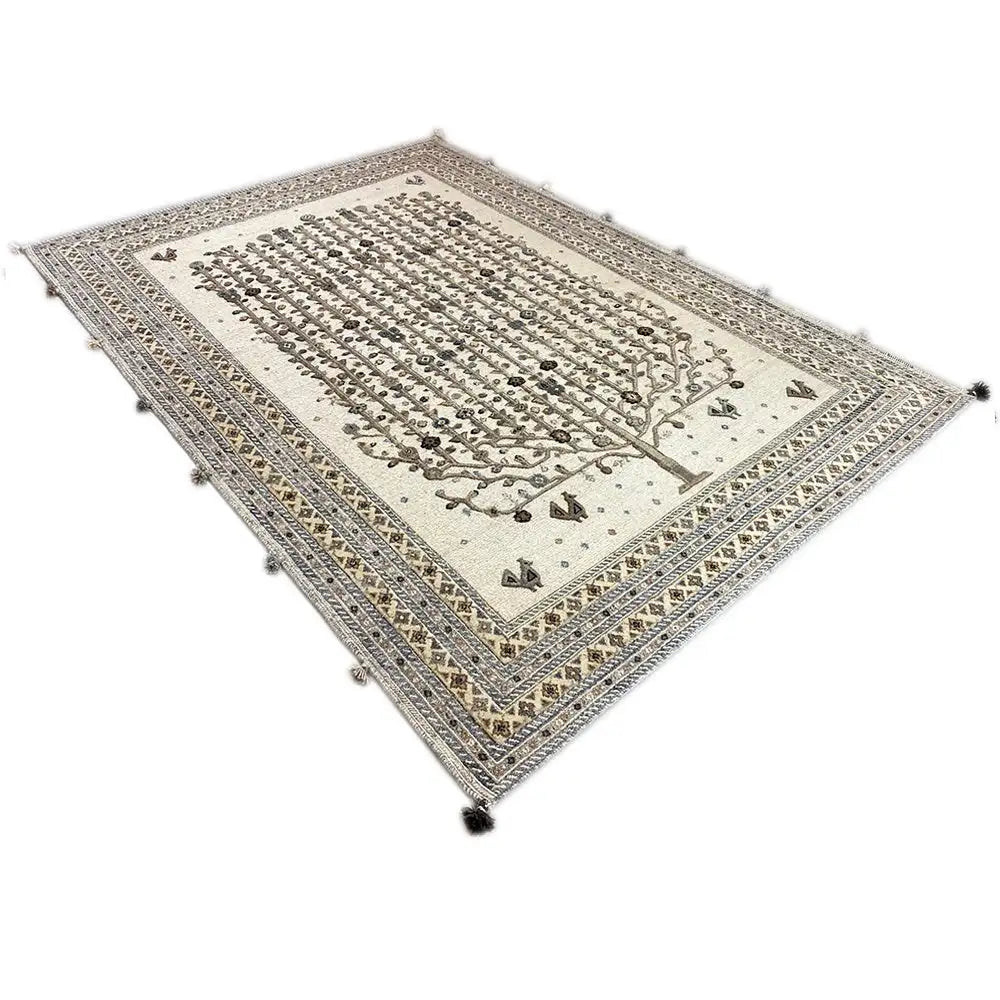 Rectangular rug with a tree motif in the center and a muted gold and dark brown pattern