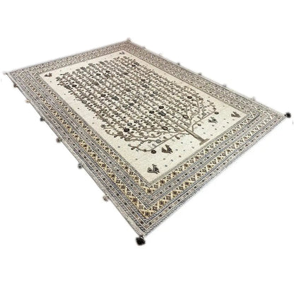 Rectangular rug with a tree motif in the center and a muted gold and dark brown pattern