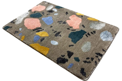 Beige rug with an abstract pattern of color blocks and dark dots, rectangular