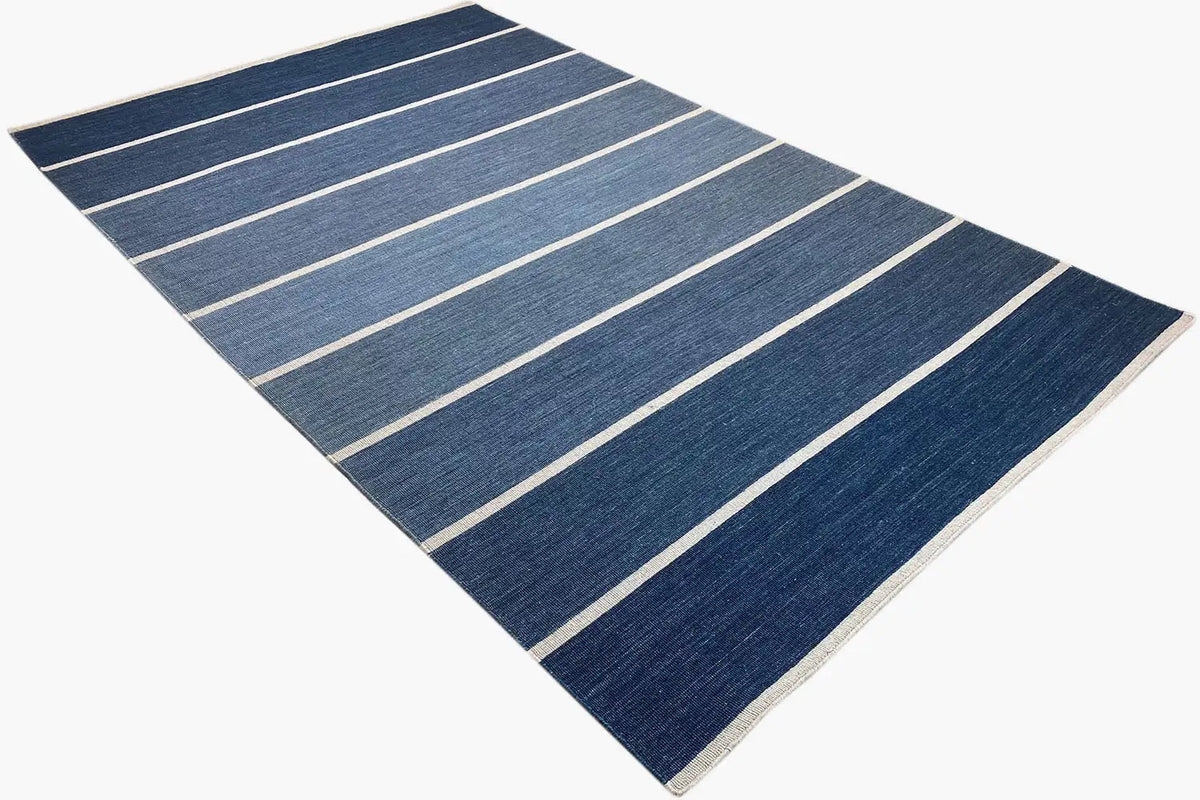 Rectangular kilim laid diagonally, with dark blue and beige lines